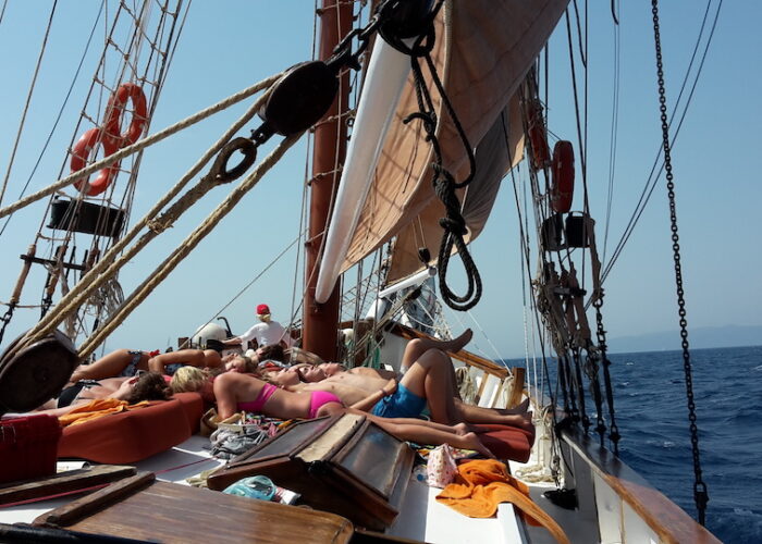 On deck sunbathing under sail
